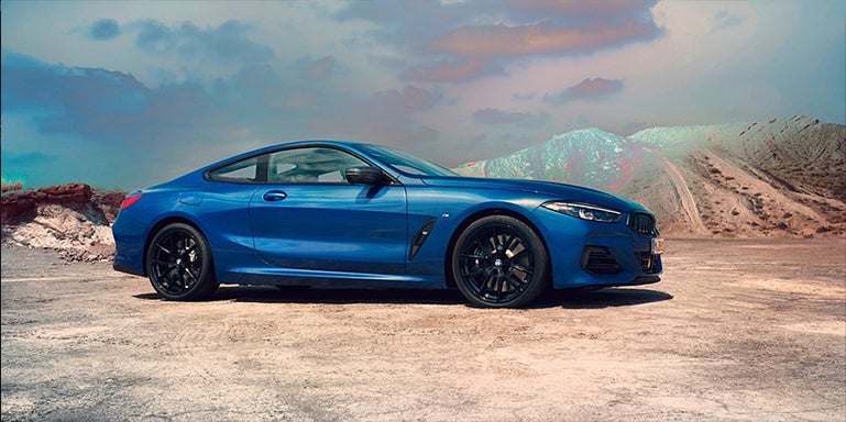 Blue BMW 8 Series parked with desert landscape | Open Road BMW of Edison in Edison NJ