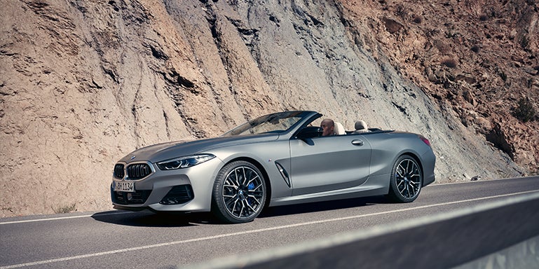 Grey BMW convertible driving around a mountain | Open Road BMW of Edison in Edison NJ